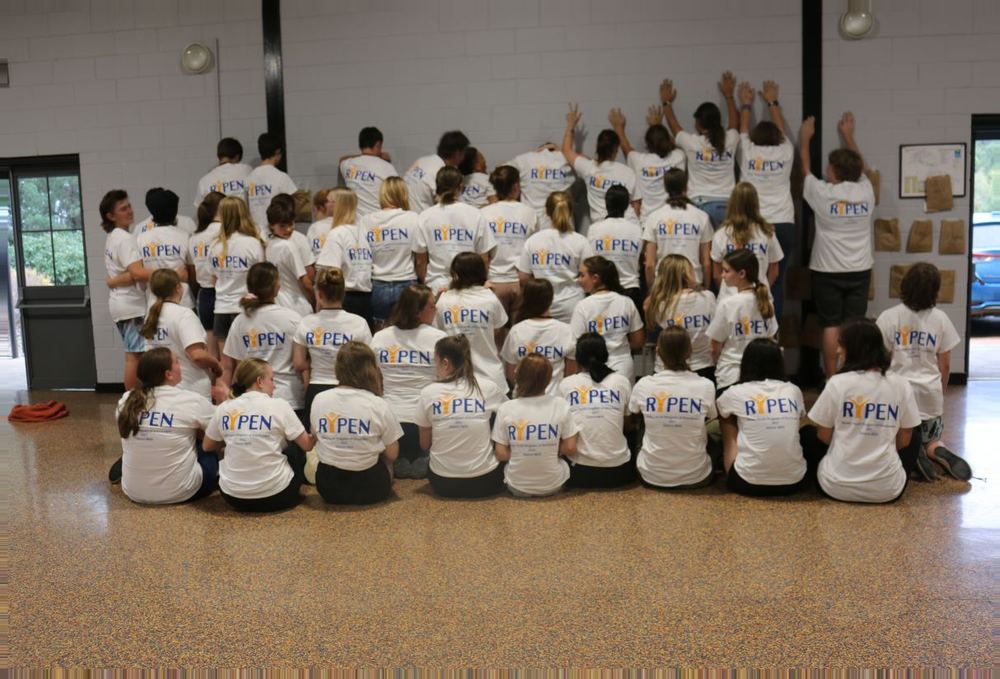RYPEN participants in program shirts gathered together during a camp session